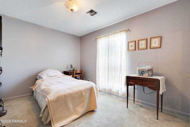 carpeted bedroom with visible vents and baseboards