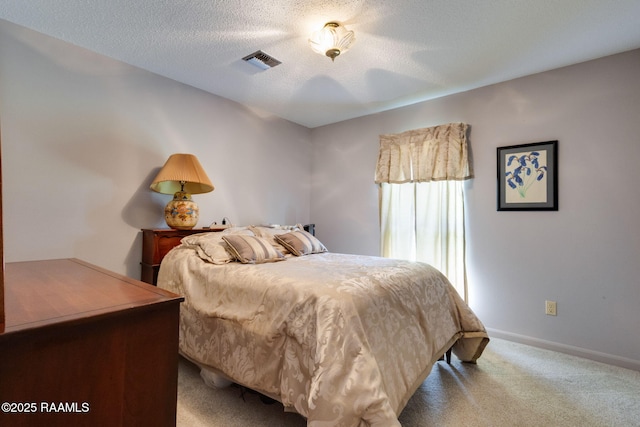 carpeted bedroom featuring visible vents, baseboards, and a textured ceiling