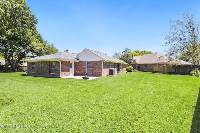 rear view of house featuring fence, cooling unit, a patio, and a lawn