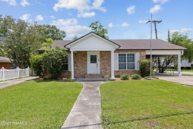 311 S Morgan Ave, Broussard, LA 70518 - view of front of property with fence, a carport, a front yard, brick siding, and roof with shingles