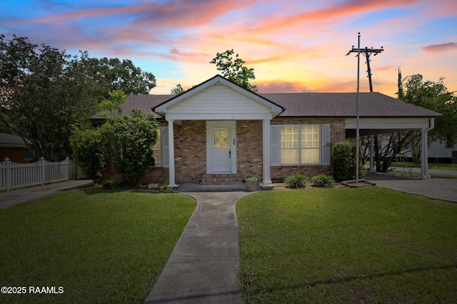 311 S Morgan Ave, Broussard, LA 70518 - view of front of house featuring fence, brick siding, driveway, a carport, and a lawn