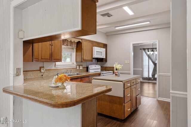 311 S Morgan Ave, Broussard, LA 70518 - kitchen featuring a sink, brown cabinetry, dark wood-type flooring, visible vents, and white appliances