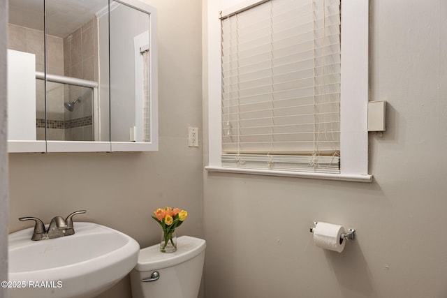 311 S Morgan Ave, Broussard, LA 70518 - bathroom featuring toilet, tiled shower, and a sink