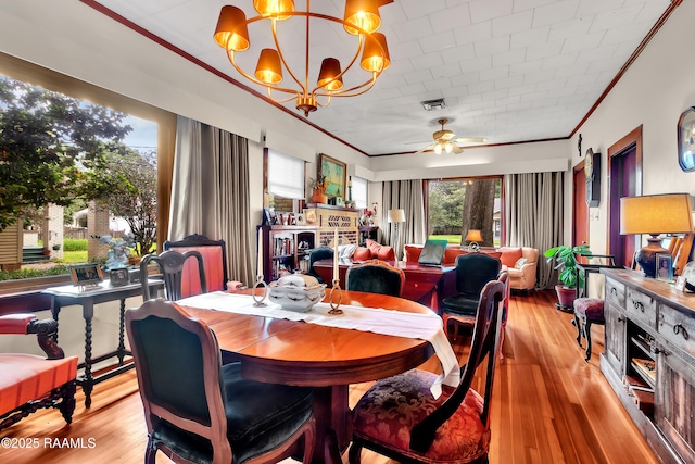 1703 W University Ave, Lafayette, LA 70506 - dining area featuring visible vents, ornamental molding, wood finished floors, and ceiling fan with notable chandelier