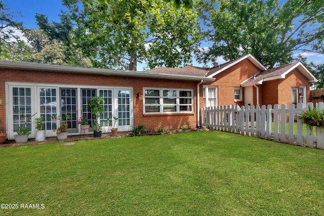 1703 W University Ave, Lafayette, LA 70506 - rear view of house with brick siding, a lawn, and fence