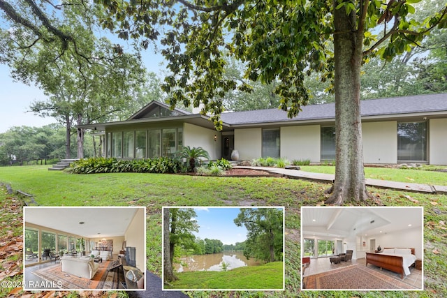 1 Eureka Plantation Rd, Lafayette, LA 70508 - view of front of home featuring stucco siding, a front lawn, and a water view
