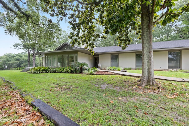 1 Eureka Plantation Rd, Lafayette, LA 70508 - view of front of property with stucco siding, a front lawn, and a sunroom