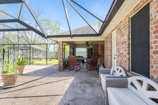 view of patio featuring an outdoor living space, glass enclosure, and ceiling fan