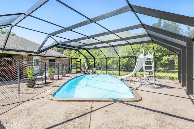 pool featuring a patio, glass enclosure, and a water slide