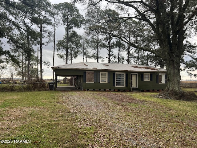view of front of house featuring a carport, a front yard, fence, and metal roof