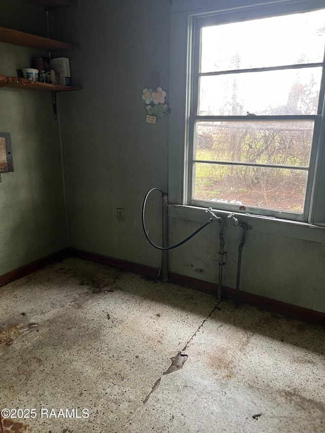 spare room featuring baseboards and plenty of natural light