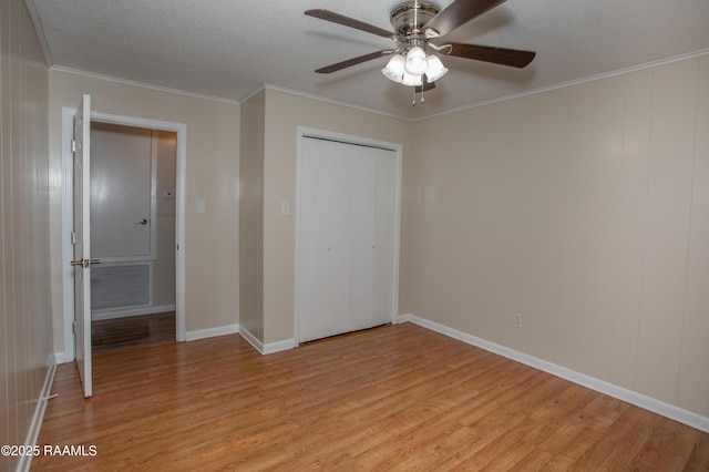 140 Saint Leo St, Opelousas, LA 70570 - unfurnished bedroom with a closet, ornamental molding, a textured ceiling, light wood-style floors, and visible vents
