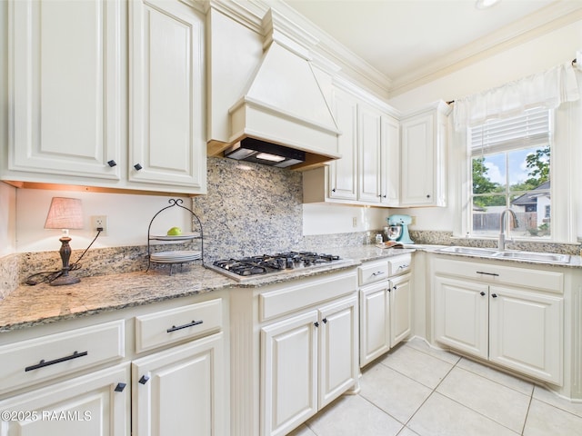 111 Croft Row, Lafayette, LA 70503 - kitchen featuring stainless steel gas cooktop, a sink, light tile patterned floors, ornamental molding, and custom range hood
