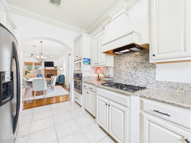 111 Croft Row, Lafayette, LA 70503 - kitchen featuring arched walkways, premium range hood, a chandelier, ornamental molding, and stainless steel appliances