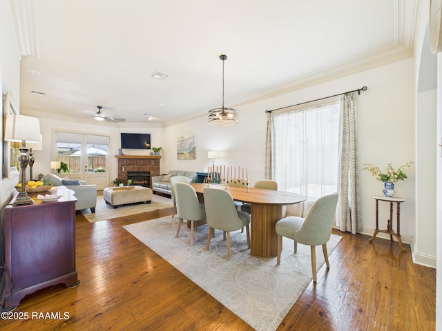 111 Croft Row, Lafayette, LA 70503 - dining space featuring a fireplace, crown molding, ceiling fan, and dark wood finished floors