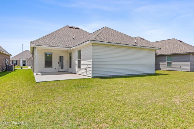 rear view of house with a patio, a yard, and roof with shingles