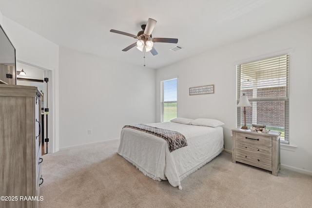 bedroom featuring visible vents, baseboards, ceiling fan, and light colored carpet