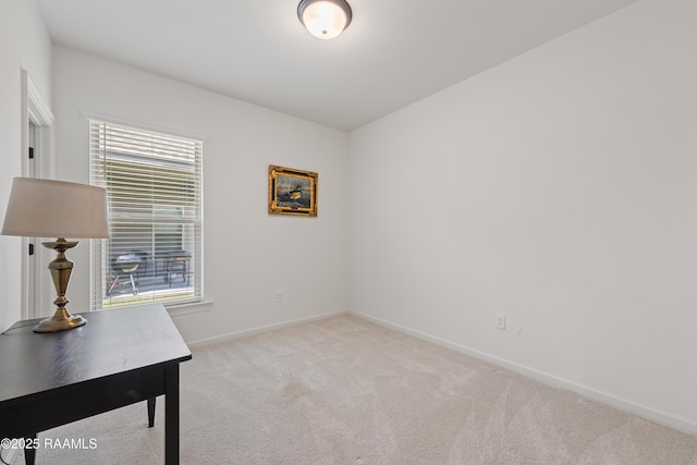 unfurnished office featuring a wealth of natural light, light colored carpet, and baseboards