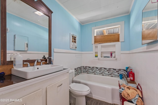 full bathroom featuring crown molding, a bath, vanity, and toilet