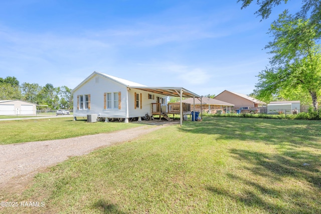 view of front of house featuring a carport, a front lawn, and fence