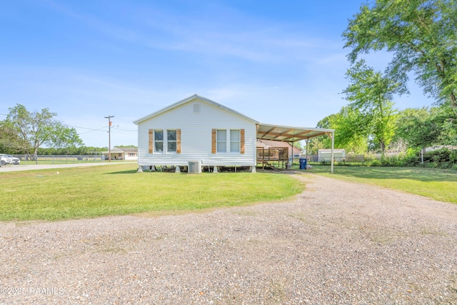 manufactured / mobile home with central air condition unit, an attached carport, a front lawn, and dirt driveway