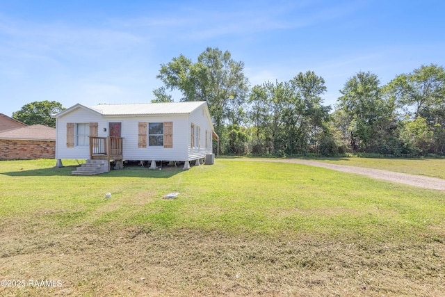 manufactured / mobile home featuring metal roof and a front lawn