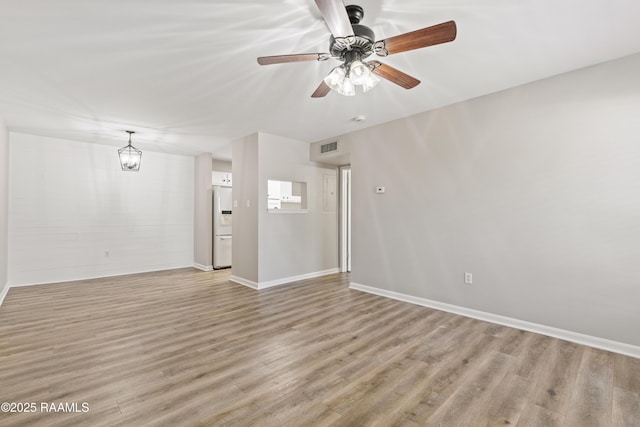 701 S College Rd Unit 303, Lafayette, LA 70503 - unfurnished living room featuring light wood-style floors, baseboards, visible vents, and ceiling fan with notable chandelier