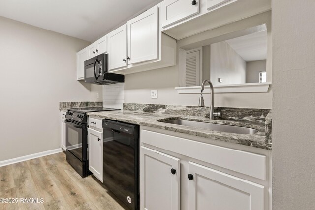 701 S College Rd Unit 303, Lafayette, LA 70503 - kitchen with white cabinets, light stone countertops, black appliances, light wood finished floors, and a sink