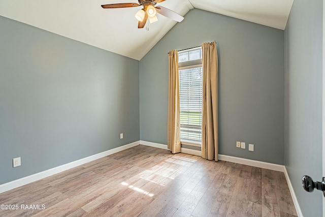 spare room featuring a ceiling fan, baseboards, vaulted ceiling, and wood-type flooring