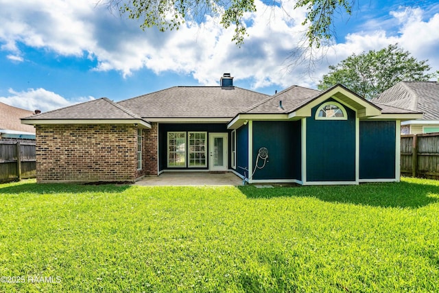 rear view of property with a chimney, fence, and a yard