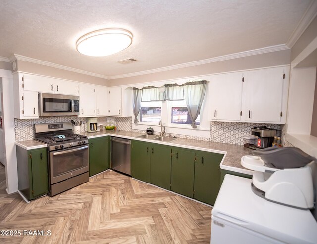 1207 Oak St, Ville Platte, LA 70586 - kitchen with visible vents, crown molding, green cabinetry, a sink, and stainless steel appliances