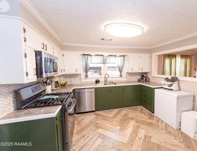 1207 Oak St, Ville Platte, LA 70586 - kitchen featuring white cabinets, green cabinetry, appliances with stainless steel finishes, a sink, and visible vents
