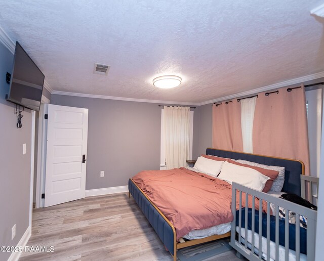 1207 Oak St, Ville Platte, LA 70586 - bedroom featuring baseboards, a textured ceiling, light wood-style flooring, and crown molding