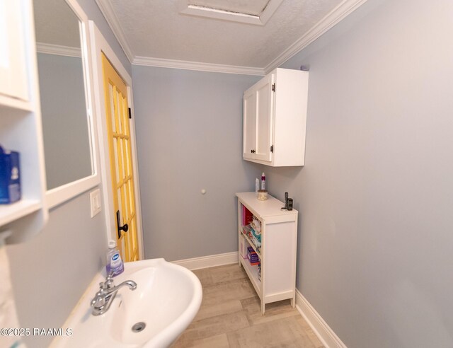 1207 Oak St, Ville Platte, LA 70586 - bathroom with crown molding, baseboards, a sink, and wood finished floors