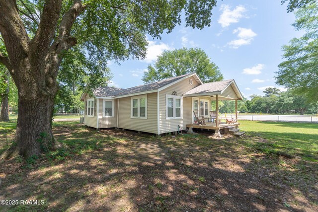 1207 Oak St, Ville Platte, LA 70586 - back of house with fence, a deck, a lawn, and roof with shingles