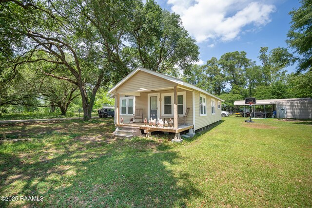 1207 Oak St, Ville Platte, LA 70586 - back of house featuring covered porch and a yard