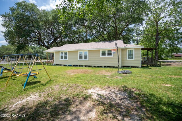 1207 Oak St, Ville Platte, LA 70586 - rear view of house featuring a playground and a lawn