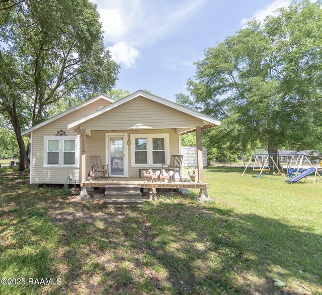 1207 Oak St, Ville Platte, LA 70586 - rear view of house featuring a lawn and a playground