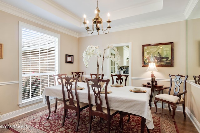202 N Anita St, Lafayette, LA 70501 - dining space with an inviting chandelier, a tray ceiling, wood finished floors, crown molding, and baseboards
