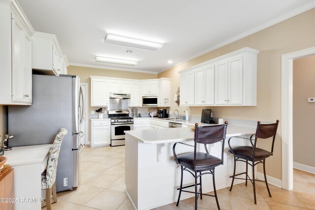 202 N Anita St, Lafayette, LA 70501 - kitchen with a peninsula, a kitchen bar, appliances with stainless steel finishes, under cabinet range hood, and light tile patterned floors