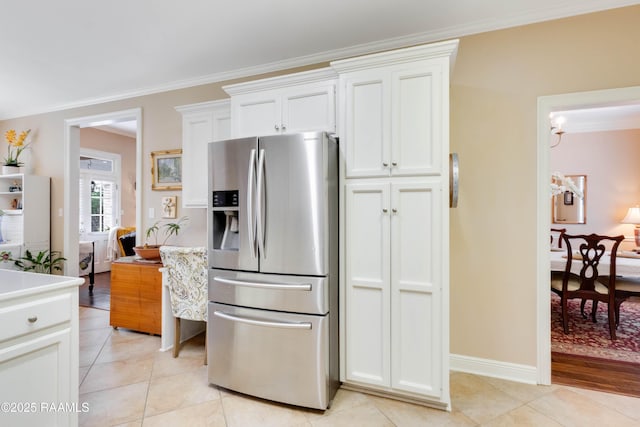 202 N Anita St, Lafayette, LA 70501 - kitchen with light countertops, light tile patterned floors, crown molding, stainless steel fridge, and white cabinetry