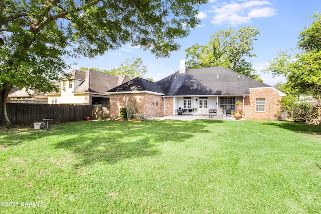 202 N Anita St, Lafayette, LA 70501 - rear view of property with fence, french doors, a patio, a lawn, and brick siding