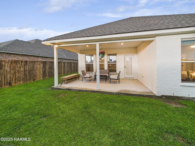 rear view of house with brick siding, roof with shingles, and a patio area