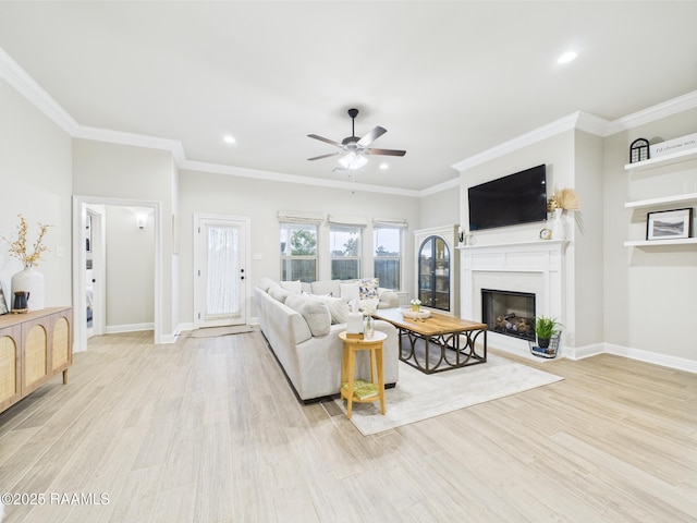 living room featuring a ceiling fan, wood finished floors, recessed lighting, a glass covered fireplace, and ornamental molding