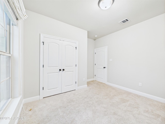 unfurnished bedroom with carpet, baseboards, and a closet
