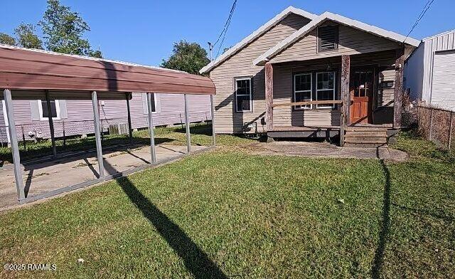 exterior space featuring covered porch and a front yard
