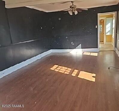 spare room featuring baseboards, a ceiling fan, and wood finished floors