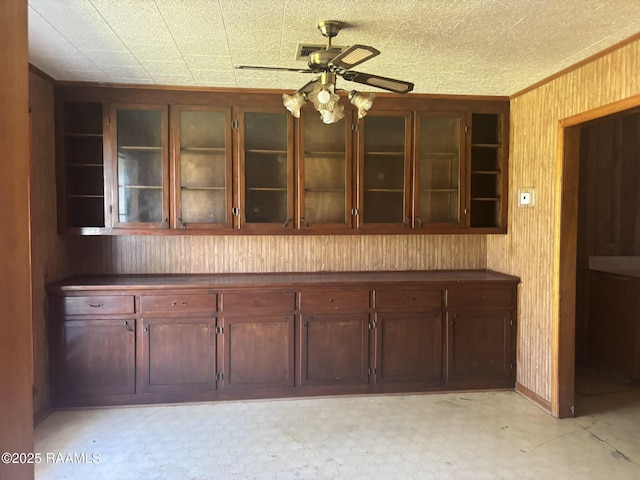 kitchen featuring open shelves, dark countertops, glass insert cabinets, and a ceiling fan