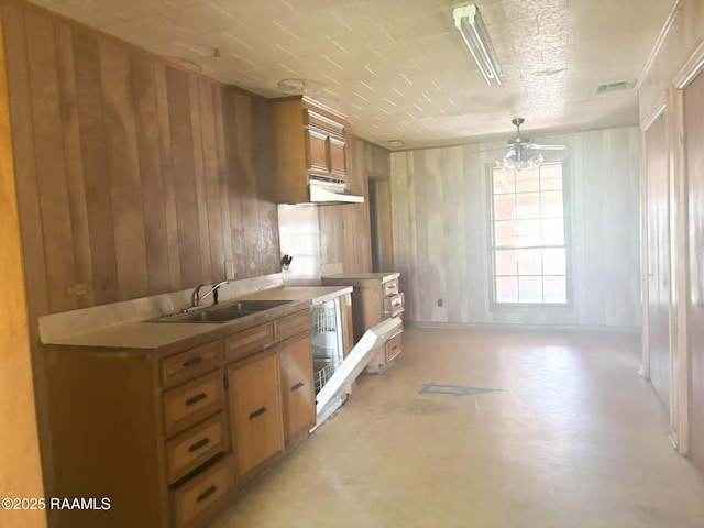 kitchen featuring concrete flooring, visible vents, light countertops, a sink, and brown cabinets