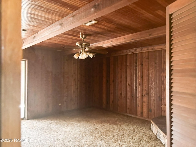 spare room featuring visible vents, wooden ceiling, a ceiling fan, wooden walls, and carpet floors